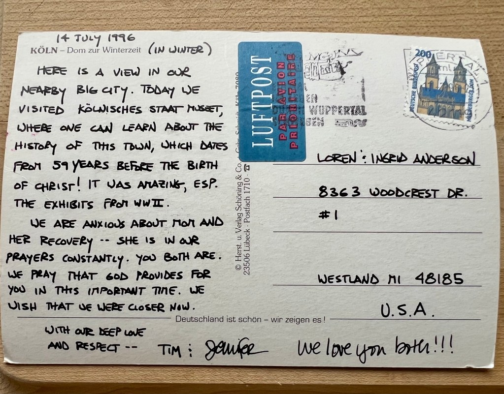 A postcard dated 14 July 1996, featuring a view from Köln, Germany, with handwritten notes about visiting the city's museum and experiencing exhibits from World War II. The postcard includes addresses and a message expressing care and prayers for someone named Mom.